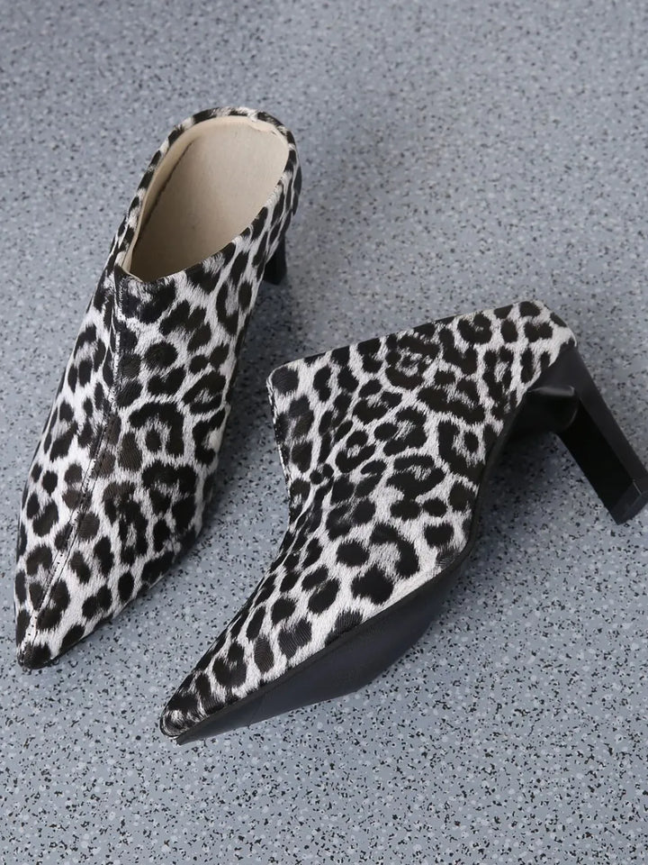 Leopard print mules on a gray textured surface