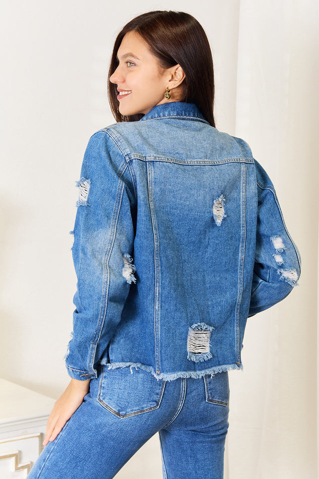Woman wearing a blue denim jacket and jeans against a white background
