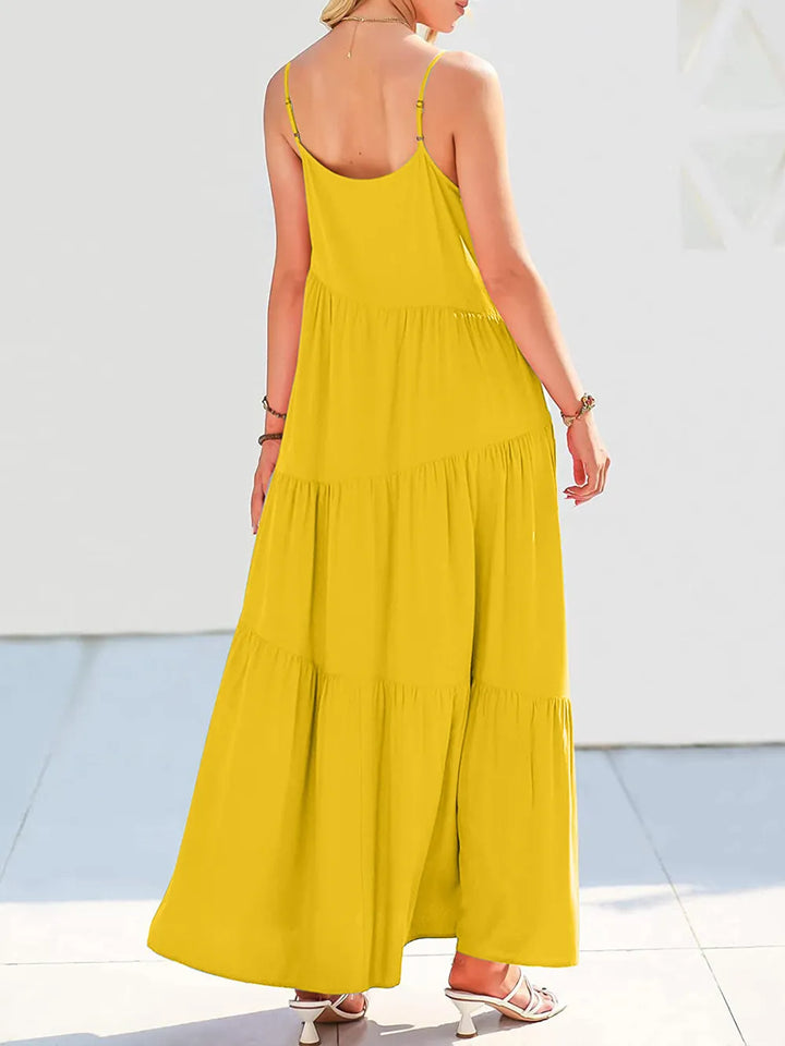 Woman wearing a yellow maxi dress with thin straps on a white background