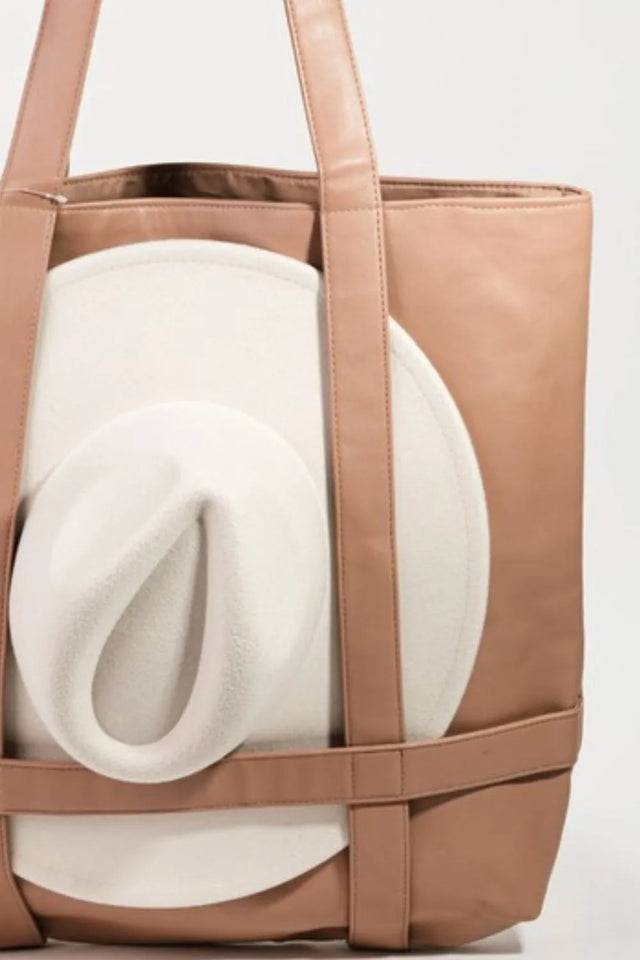 Brown tote bag with a white cushion inside on a light gray background