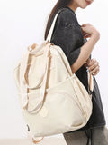 Person holding a beige backpack against a white background