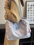 Person holding a woven handbag with a visible brand logo in an indoor setting.