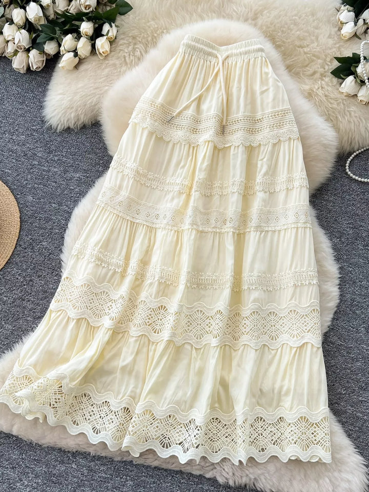 Cream-colored lace dress on a textured surface with flowers in the background