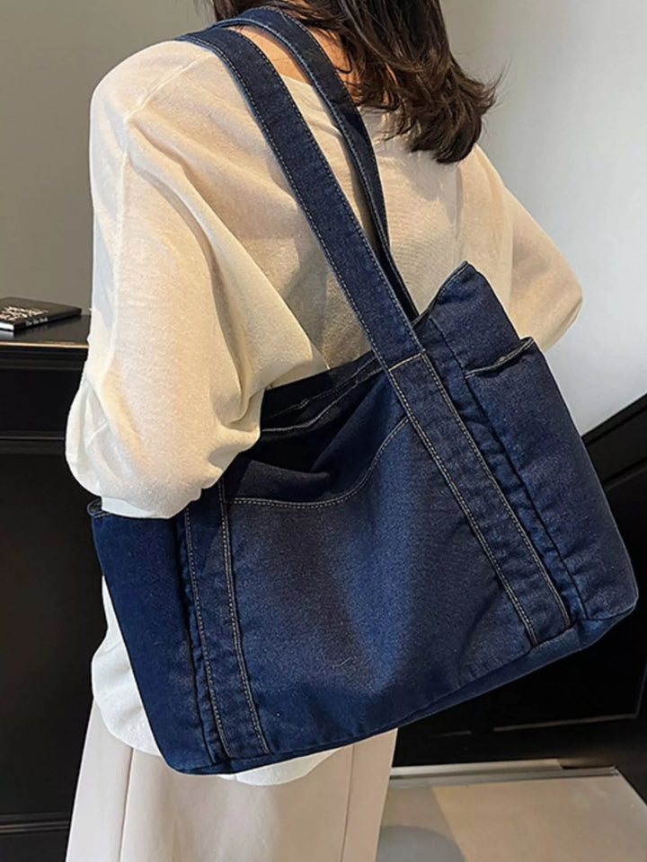 Person wearing a blue denim crossbody bag indoors
