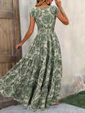 Woman wearing a green floral dress against a neutral wall.