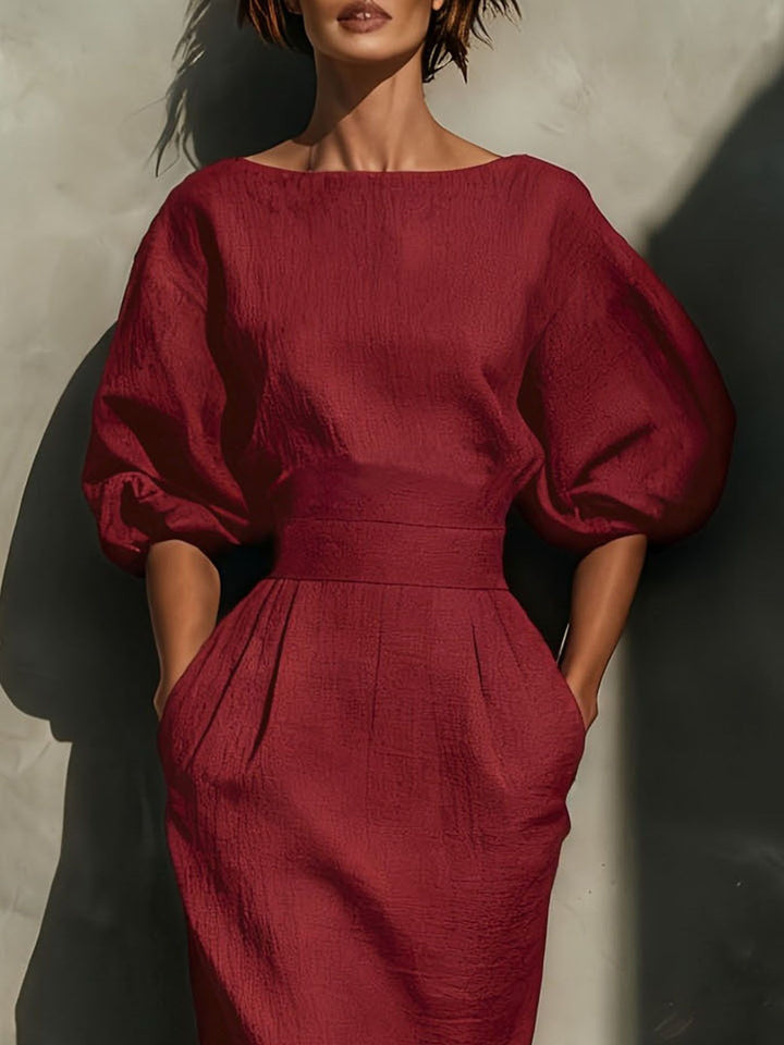 Red dress with puff sleeves worn by a model against a neutral background