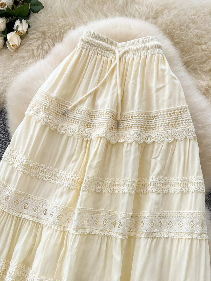 Cream-colored lace-trimmed skirt on a fluffy white surface with flowers in the corner.