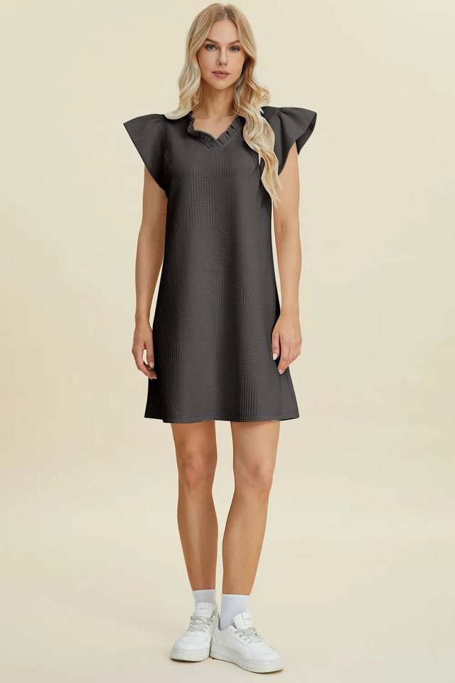 Woman wearing a dark gray dress on a beige background