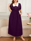 Woman wearing a purple dress with a white collar in a living room setting.