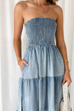 Woman wearing a strapless denim dress against a white background