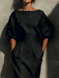 Person wearing a black outfit against a neutral background