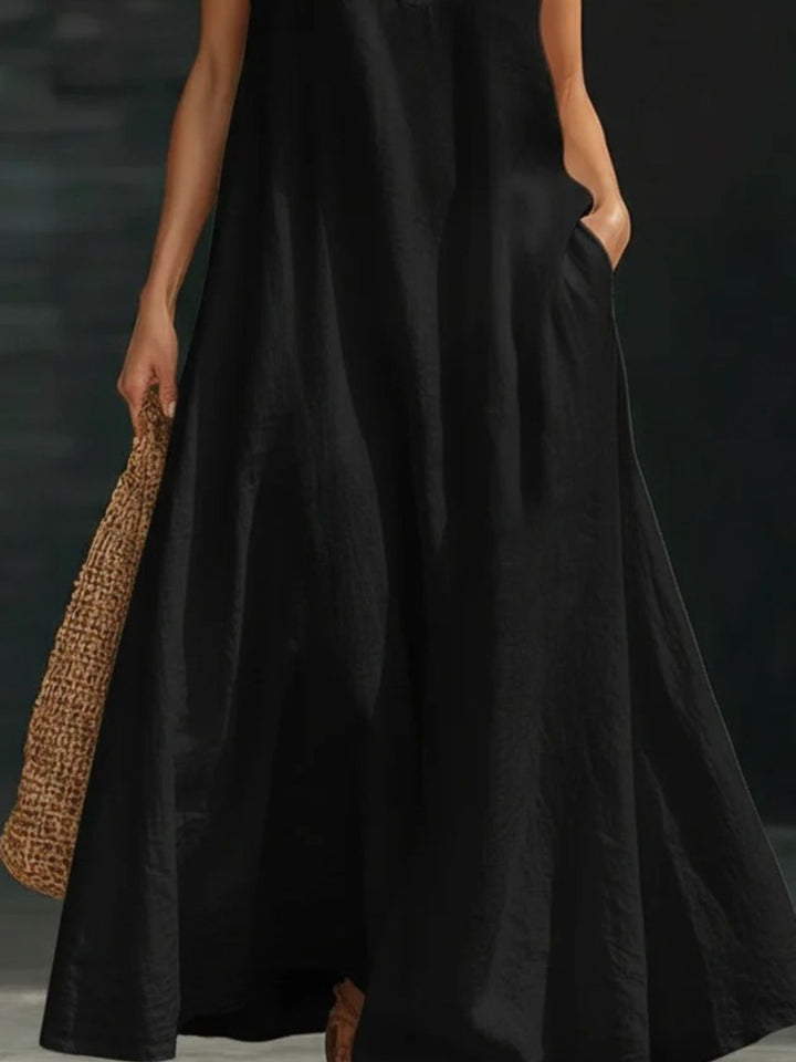 Person wearing a black dress holding a leopard print bag against a dark background