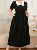 Black dress with white collar worn by a person in an indoor setting