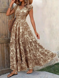 Woman wearing a floral dress standing against a wooden door.