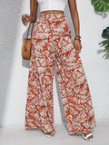 Person wearing red and white patterned wide-leg pants with a white top on a light gray background.