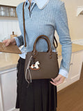 Person holding a brown handbag with a horse design in a kitchen setting