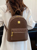 Person wearing a brown backpack with a gold zipper and logo, against a neutral background.