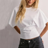Person wearing a white t-shirt and black pants against a plain background