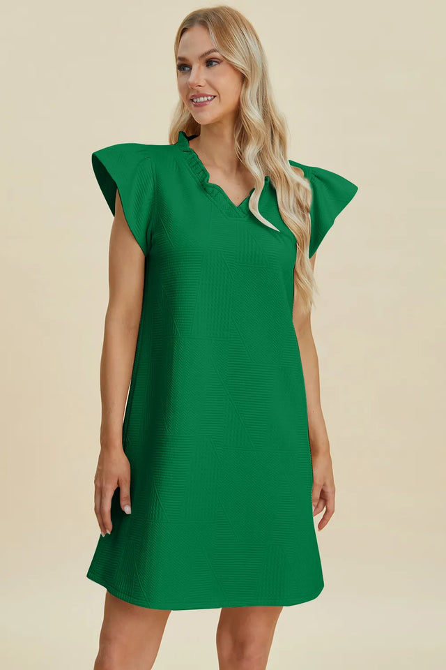 Woman wearing a green dress against a beige background