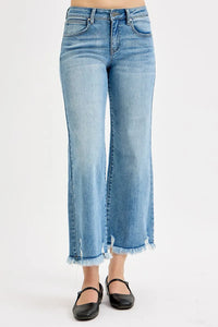 Woman wearing a brown tank top and blue jeans on a white background