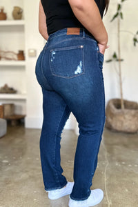 Woman wearing a black tank top and blue jeans in a living room setting