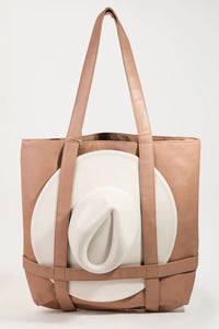 Brown tote bag with a white cylindrical object inside on a light gray background