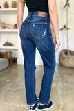 Person wearing blue jeans with a visible brand logo in an indoor setting.