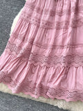 Close-up of a pink lace dress on a textured surface