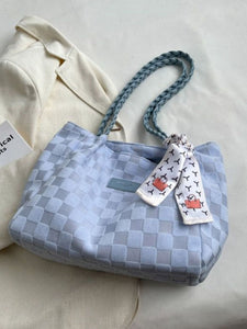 Blue checkered tote bag with a decorative strap on a light background
