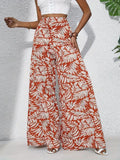 Person wearing red and white leaf-patterned wide-leg pants on a light gray background