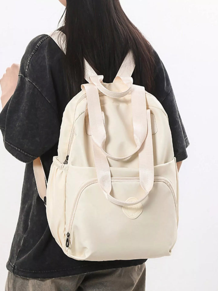 Person wearing a beige backpack on a plain background