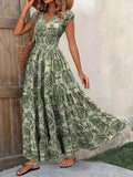 Woman wearing a green floral dress standing against a wooden door.