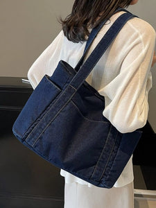 Person wearing a blue denim crossbody bag indoors