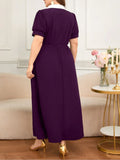 Woman wearing a purple dress in a room with a couch and decorative items.