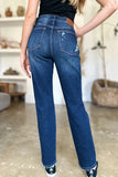 Person wearing blue jeans indoors with a blurred background