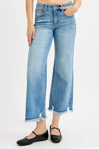 Person wearing light blue jeans with a white background