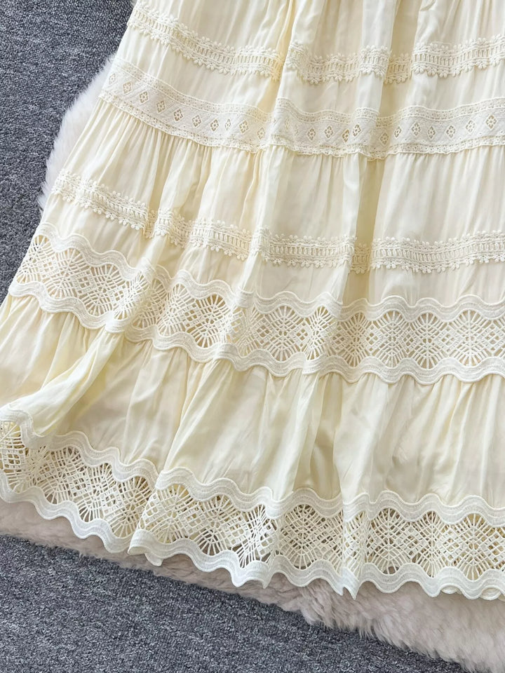 Close-up of a cream-colored lace dress on a gray surface