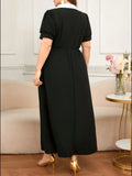 Person wearing a black dress in an indoor setting with a couch and flowers.