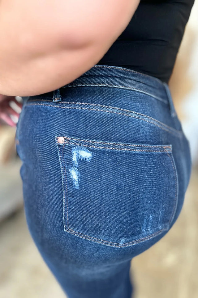 Close-up of blue jeans with a pocket showing a small tear.