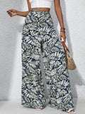 Person wearing tropical leaf print pants on a gray background