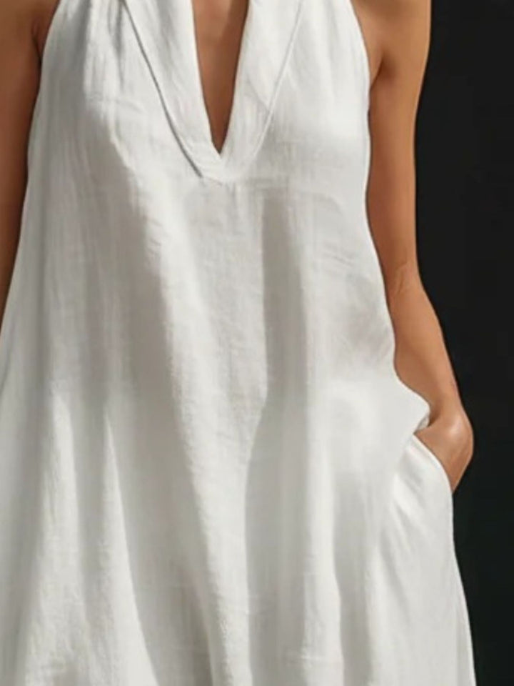White sleeveless dress worn by a person on a black background