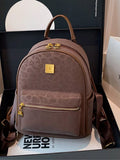 Brown backpack with gold accents on a black surface