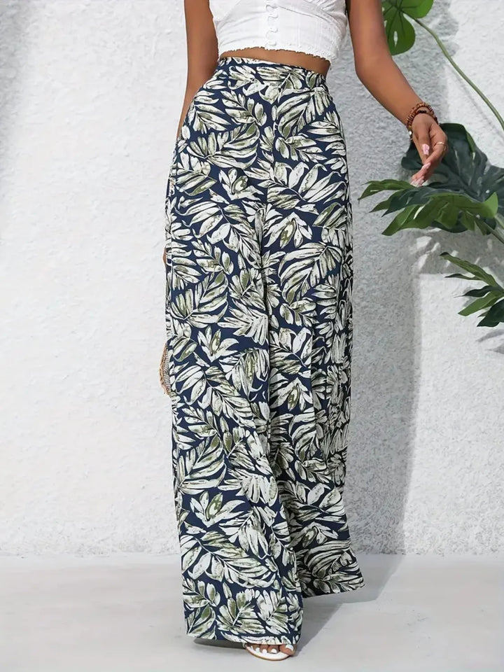 Person wearing leaf-patterned pants against a light background