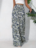 Person wearing leaf-patterned pants against a light background