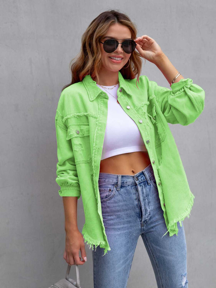 Woman wearing a bright green jacket, white crop top, and blue jeans against a gray background