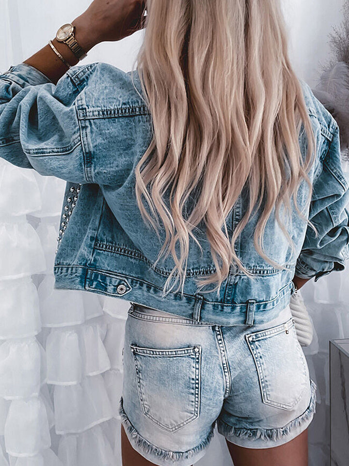 Person wearing a denim jacket and shorts with a white background