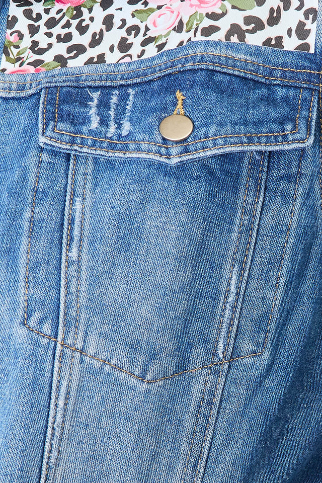 Close-up of a blue denim pocket with a floral and leopard print fabric background