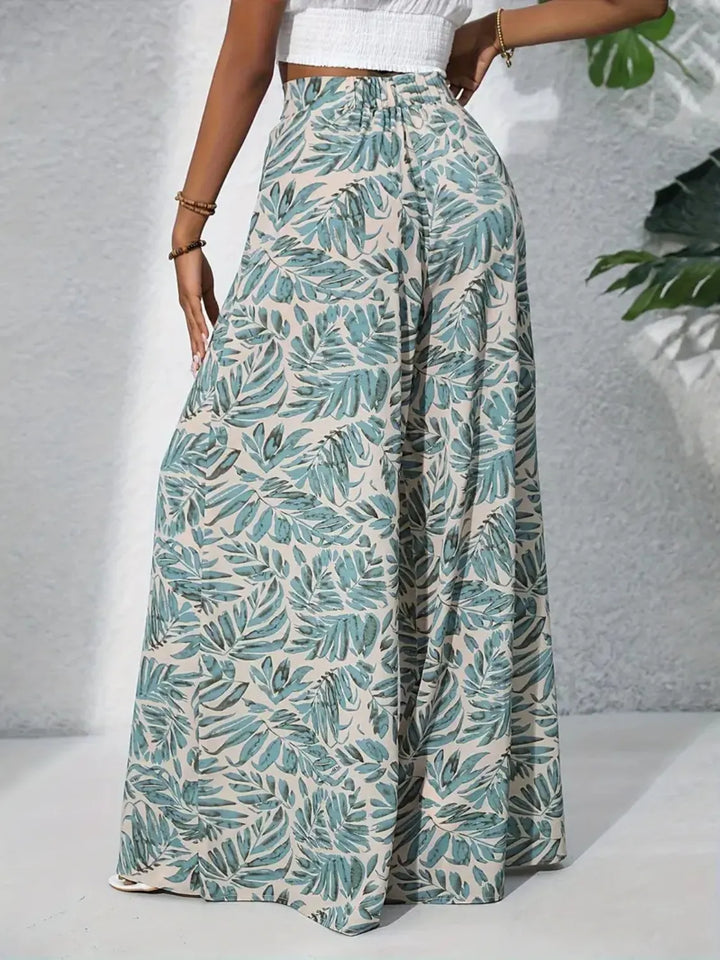 Person wearing green leaf-patterned pants on a neutral background