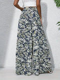 Tropical leaf patterned pants worn by a person on a light gray background