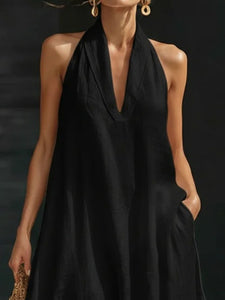 White sleeveless dress worn by a person on a black background